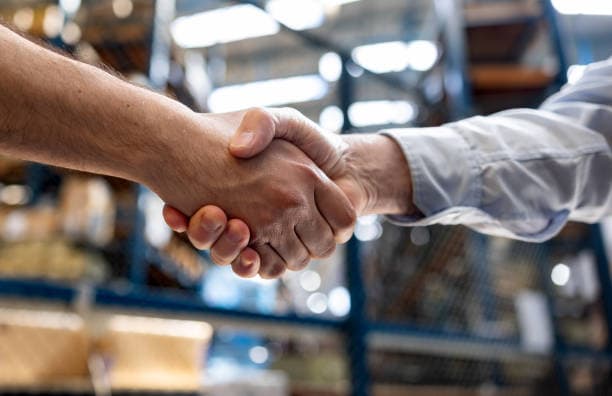 Partnership handshake in manufacturing facility for AI vision system integration