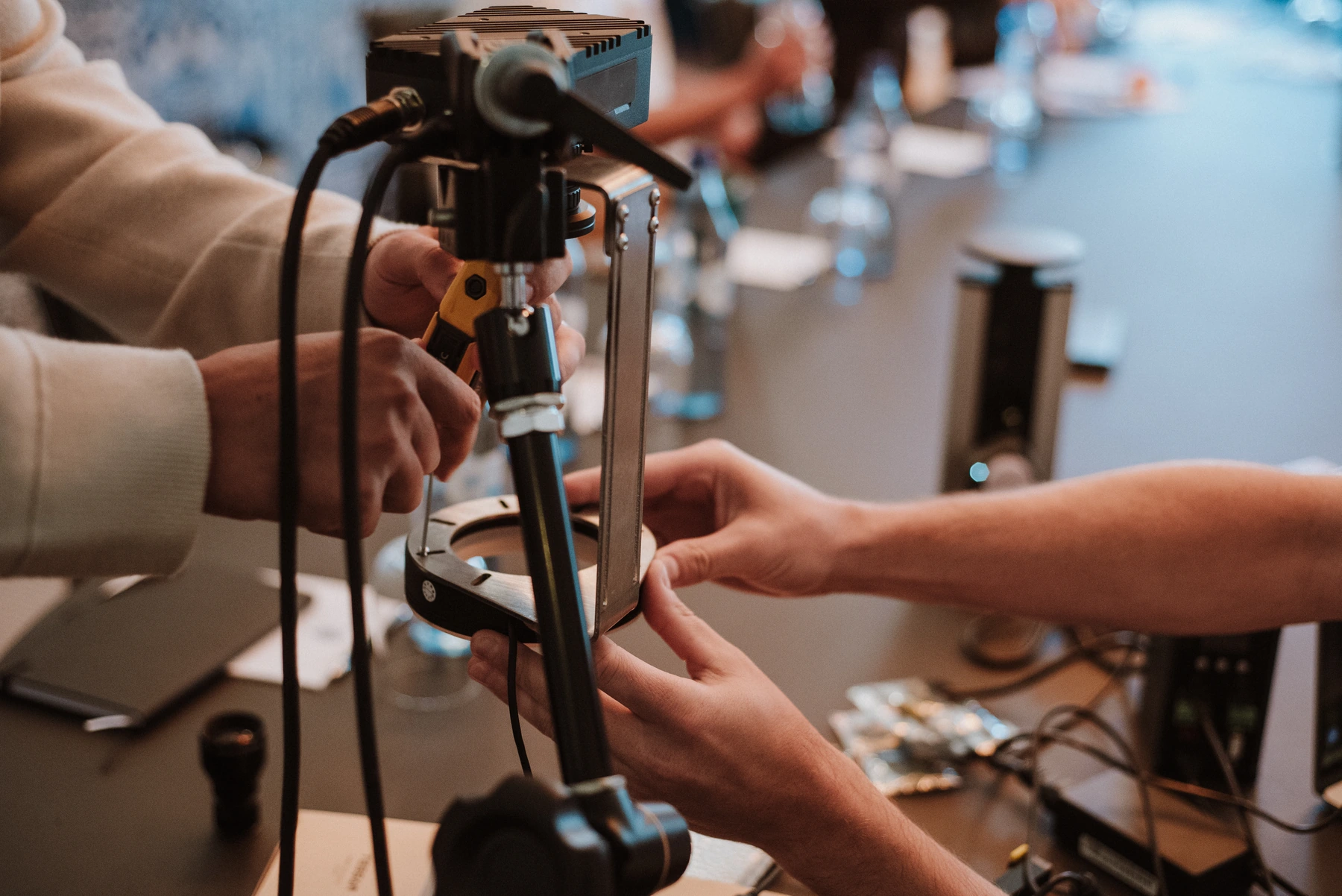 Hands adjusting the camera mount and ring light during an Overview training workshop