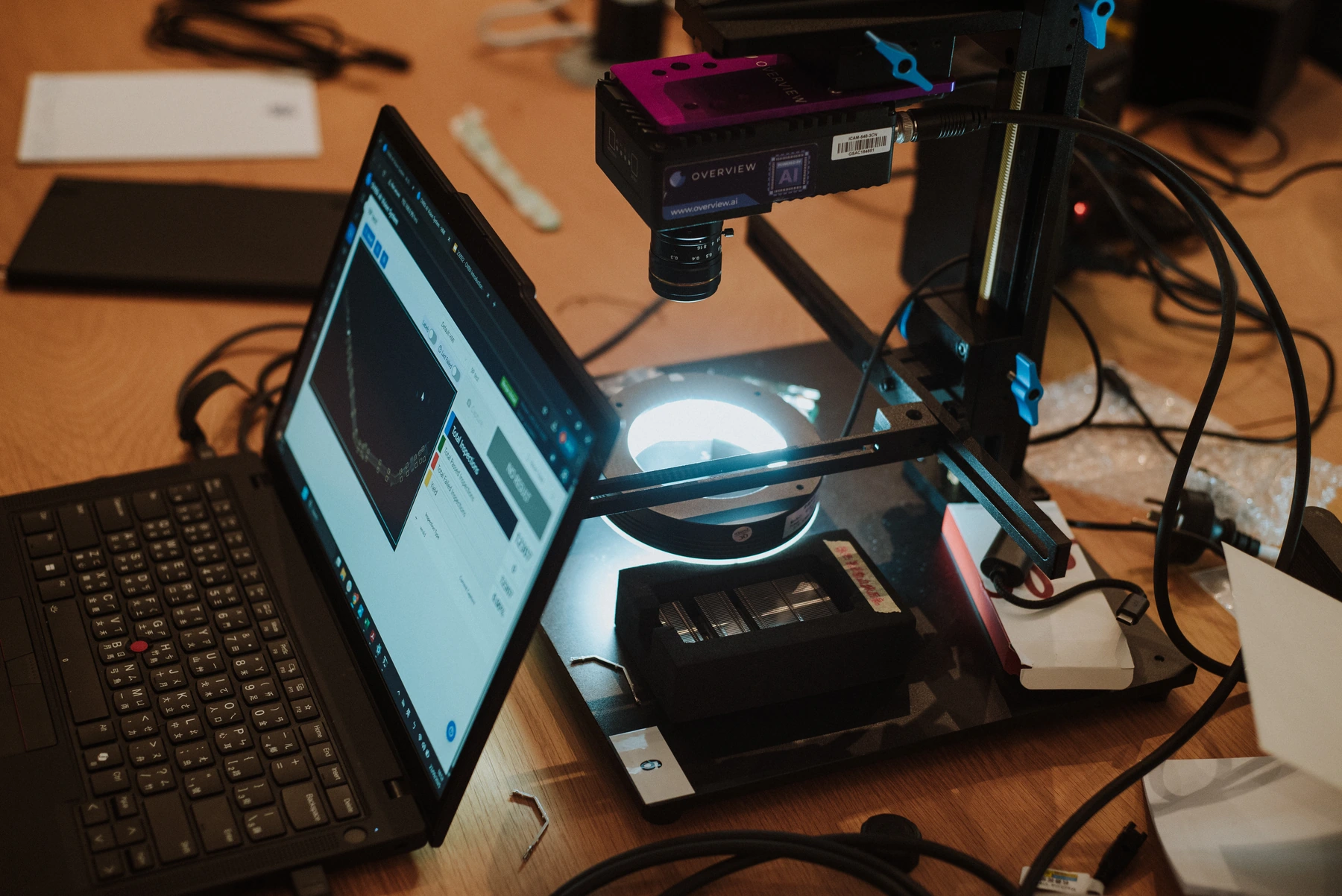 Overview camera, inspection light and laptop running inspection software at a training station