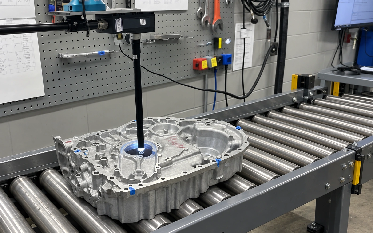 Illustrative roller-conveyor setup, edited from the original photograph of an Overview camera and borescope inspecting a transmission housing